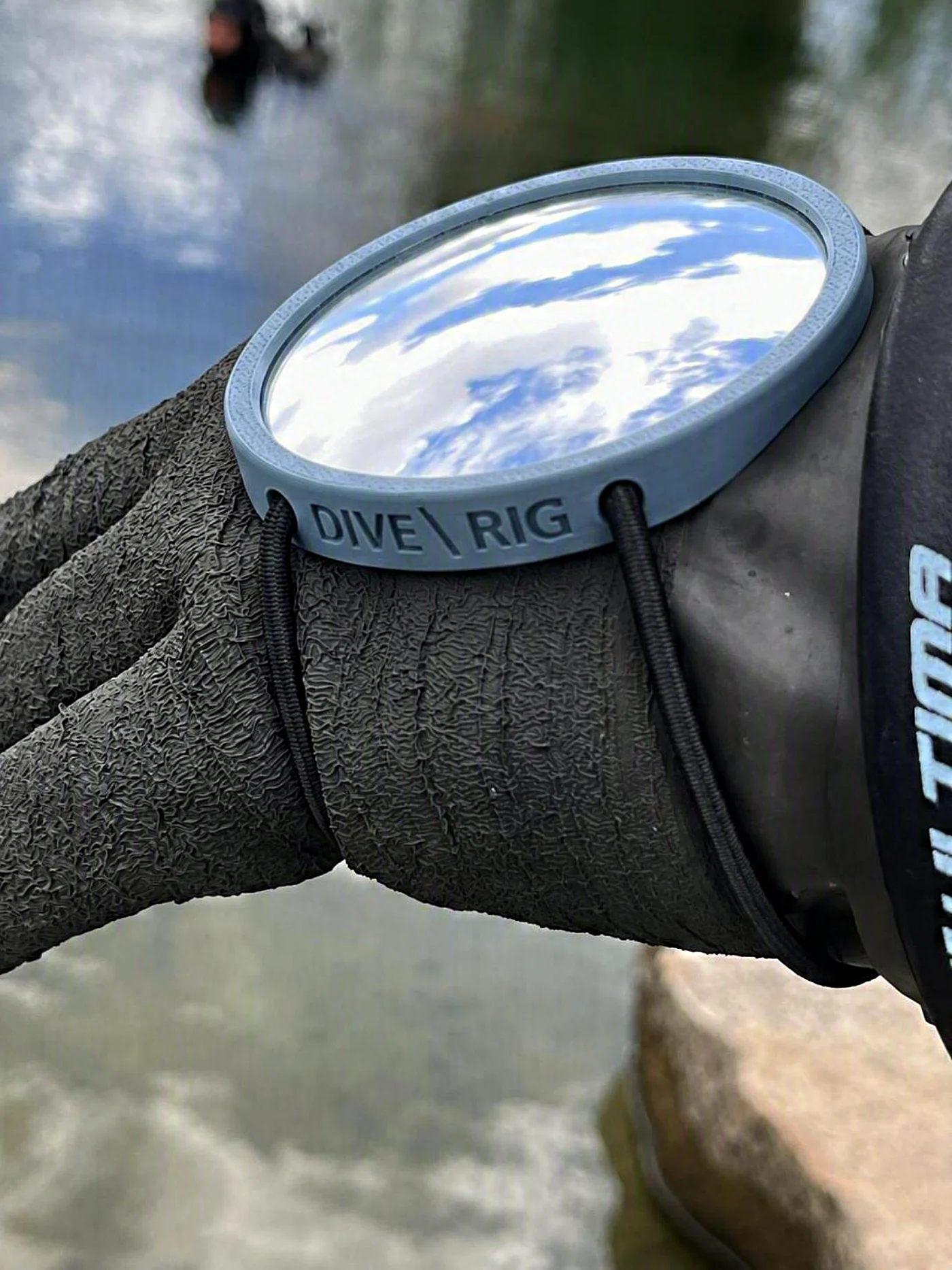 The Mirror 75 on a drysuit glove, sky reflected in the glass